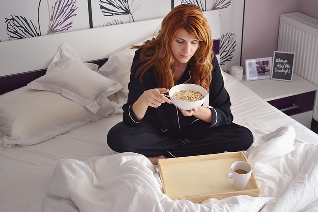 Žena snídající v posteli